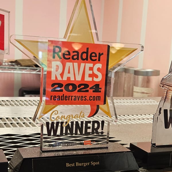A "Reader Raves 2024" award for "Best Burger Spot" on a counter at Classic Burgers.